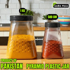 Two pyramid plastic jars filled with spices on a kitchen counter, labeled with weight and product origin.