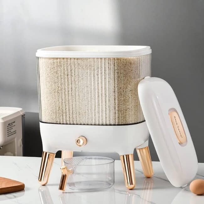 White and gold cylindrical device with a textured beige top on a reflective surface.