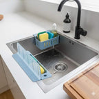 Kitchen sink with dish rack, sponge, and soap on a white countertop.