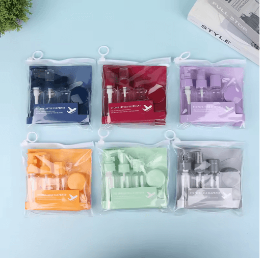 Set of six clear plastic bags containing various cosmetic items on a light blue background.
