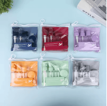 Set of six clear plastic bags containing various cosmetic items on a light blue background.