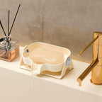 Dog water bowl on a bathroom counter with a gold faucet and diffuser in the background.