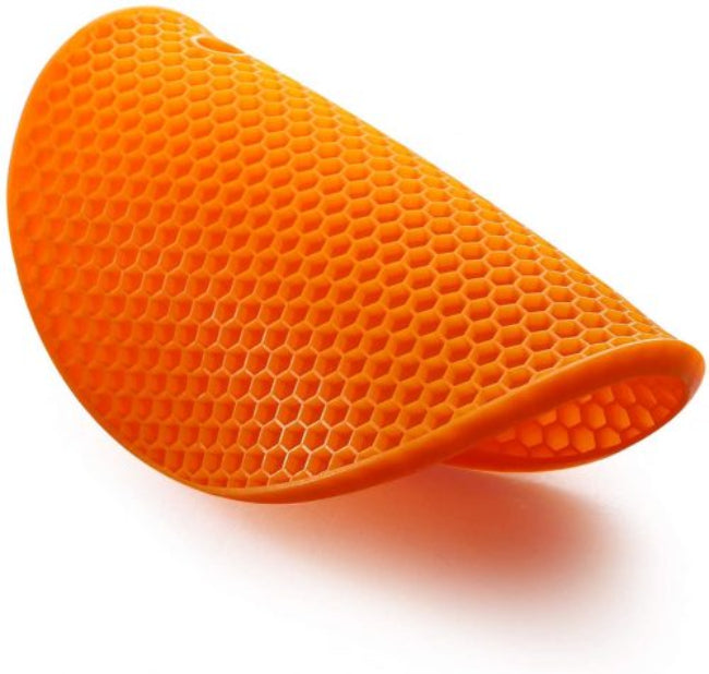 Set of geometric-patterned food grade silicone pot mats in red and black, shown with a hot metal pot placed on one to demonstrate heat resistance on a wooden countertop.