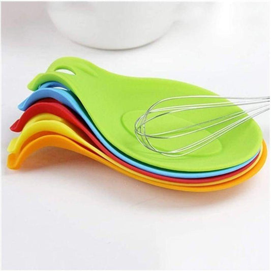 A set of five colorful silicone whisk holders in green, blue, red, yellow, and orange, stacked together with a metal wire whisk resting on the top green holder, on a white surface.