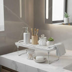 Bathroom counter with a metal tray holding various toiletries and a plant.