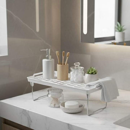 Bathroom counter with a metal tray holding various toiletries and a plant.