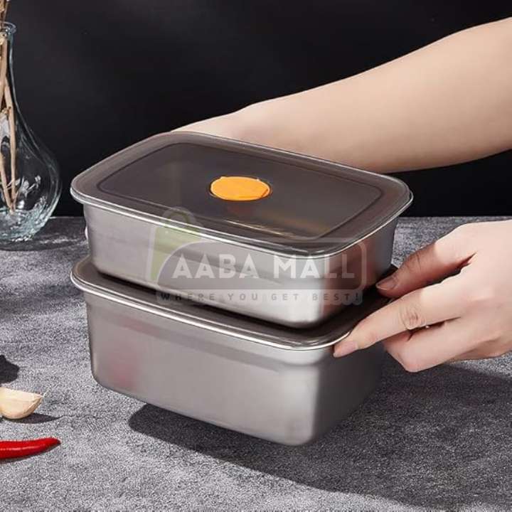 Stainless steel food containers with a hand lifting the lid on a gray surface, branded 'AABA MALL'.