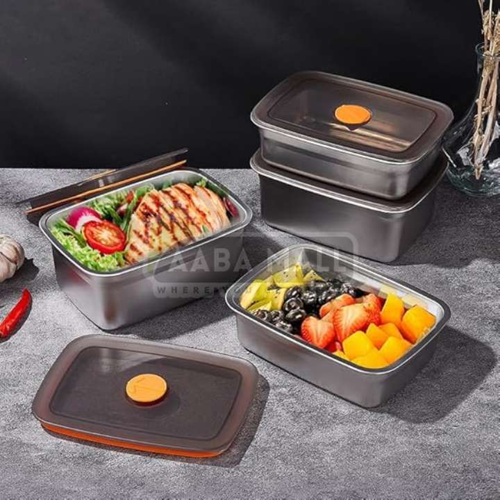 Set of stainless steel food containers with meals inside on a gray surface.