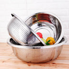 Stainless steel colander with vegetables on a wooden surface