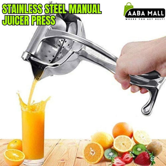 Stainless steel manual juicer press being used to extract juice from fruits with a glass of orange juice and more fruits on a wooden surface.