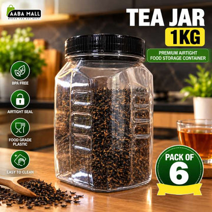 A clear plastic hexagonal tea jar with a black screw-on lid, filled with dark tea leaves, shown on a wooden table in a kitchen setting. The image includes promotional text reading 'TEA JAR 1KG' and feature icons for BPA free, airtight seal, food grade plastic, and easy to clean.