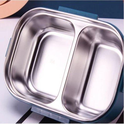 A close-up of a stainless steel two-compartment lunch tray, showing the reflective interior compartments and a dark teal outer container.