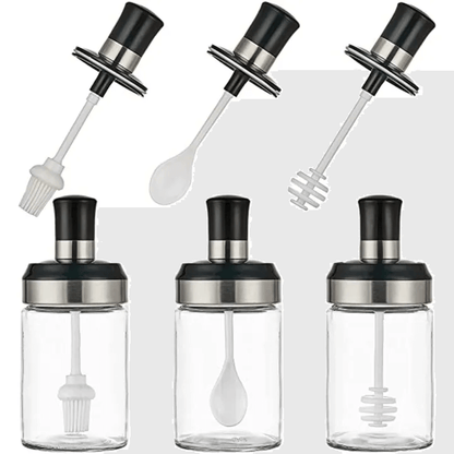 Set of four glass bottles with black and silver lids and attachments on a white background
