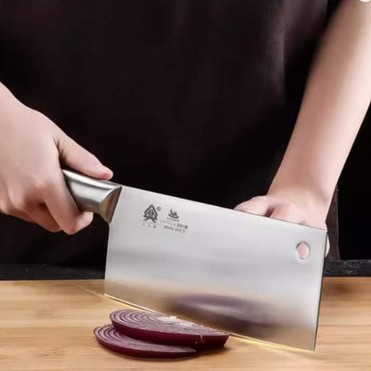 Person using a cleaver to cut red onions on a wooden cutting board with a dark background