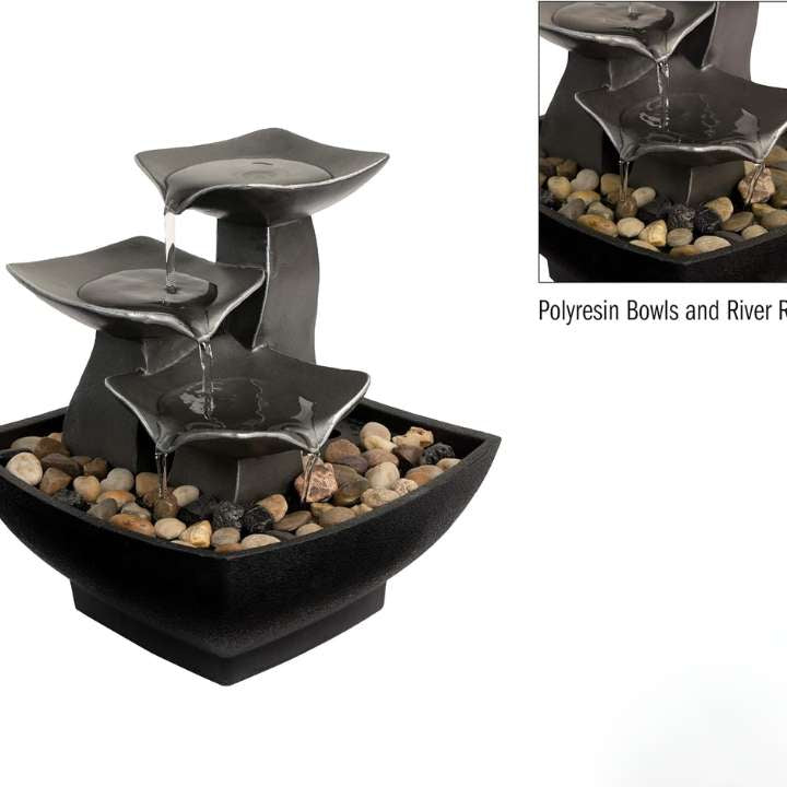 Decorative water fountain with tiered bowls and river rocks on a white background