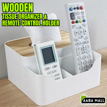 Wooden desktop organizer box with a flat top, showing a tissue box compartment on one side and three partitioned slots filled with remotes and pens on the other side.