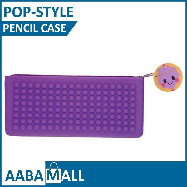 A purple silicone pop-up pencil case with a textured bubble pattern and a small cartoon character charm, shown on a white background with blue text banners.