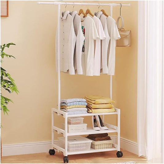 Full view of white adjustable metal clothes rack with 3 wire shelves, holding hanging clothes, shoes, and folded towels in a modern bedroom setting.