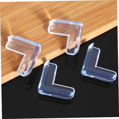 Clear L-shaped corner protectors on a wooden and black surface