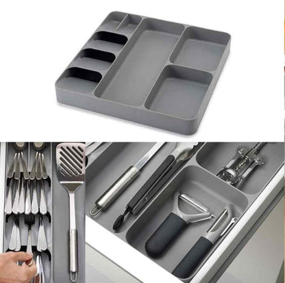 LARGE Grey plastic cutlery tray organizer shown placed inside a kitchen drawer, neatly separating a full set of silver spoons, knives, and forks in the dedicated compartments.
