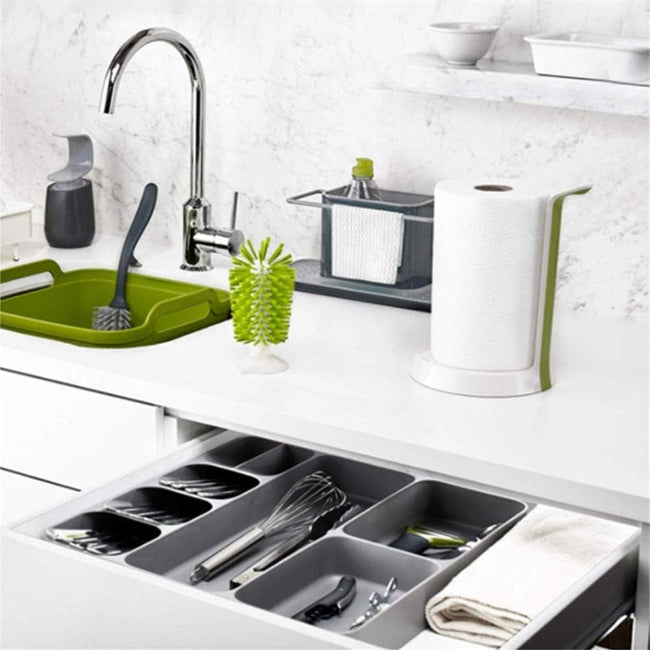 LARGE Grey plastic cutlery tray organizer shown placed inside a kitchen drawer, neatly separating a full set of silver spoons, knives, and forks in the dedicated compartments.