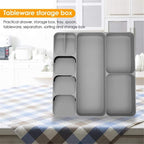 LARGE Grey plastic cutlery tray organizer shown placed inside a kitchen drawer, neatly separating a full set of silver spoons, knives, and forks in the dedicated compartments.