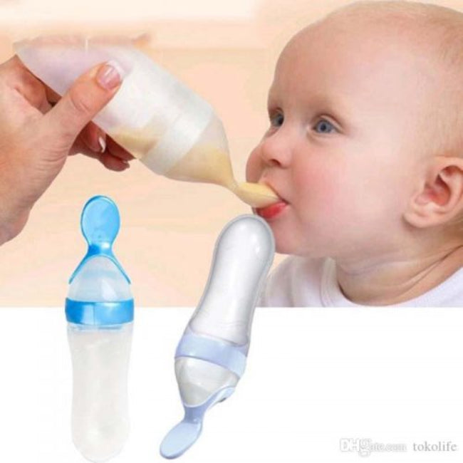 Close-up of a soft silicone baby squeeze feeder spoon, with orange pumpkin puree visible inside the bottle, illustrating the easy-to-squeeze, one-handed feeding method.