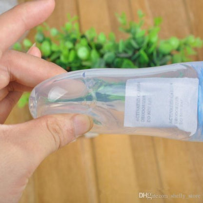 Close-up of a soft silicone baby squeeze feeder spoon, with orange pumpkin puree visible inside the bottle, illustrating the easy-to-squeeze, one-handed feeding method.