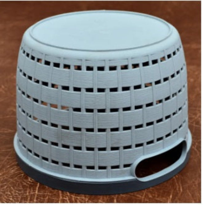 Black multipurpose wire storage basket filled with fresh red apples and oranges, sitting on a kitchen countertop, demonstrating air flow and fruit storage.