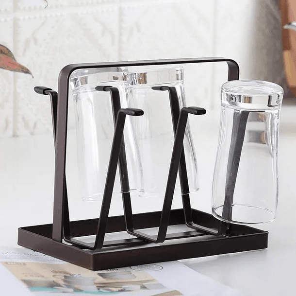 Black glass drying rack with clear glasses on a white surface
