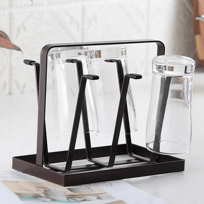 Black glass drying rack with clear glasses on a white surface