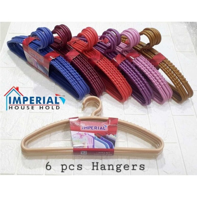 Set of 6 classic white plastic cloth hangers with swivel hooks hanging neatly in a closet, holding a mix of shirts and trousers.