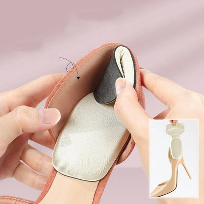 One pair of light grey adhesive memory foam heel cushion pads, shown being stuck into the back heel lining of a black shoe to demonstrate anti-wear protection and improved fit.
