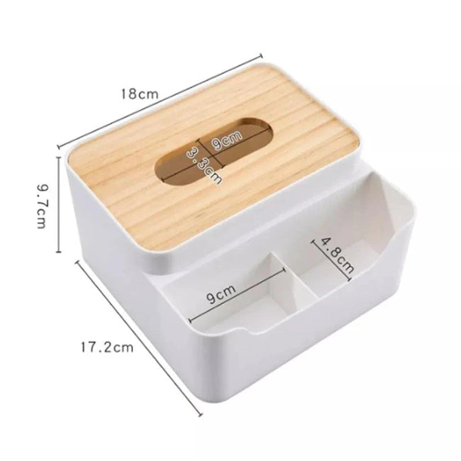 Wooden desktop organizer box with a flat top, showing a tissue box compartment on one side and three partitioned slots filled with remotes and pens on the other side.