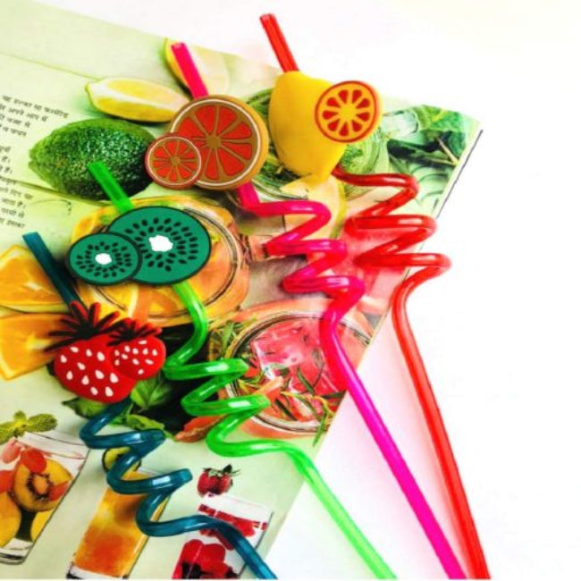 Pack of 4 reusable plastic drinking straws with colorful molded fruit tops (e.g., pineapple, strawberry), shown decorating glasses of brightly colored juice at a kids' birthday party.