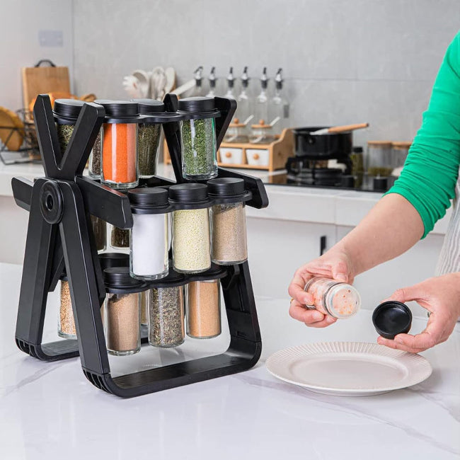 Close-up of an 18-jar stainless steel rotating spice rack organizer designed like a Ferris Wheel, showing the small glass jars filled with various colorful spices and herbs on a kitchen counter.
