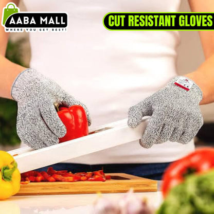 Close-up of a hand wearing a grey Level 5 cut resistant safety glove, securely holding a large onion while the other hand uses a sharp chef's knife for slicing on a cutting board.