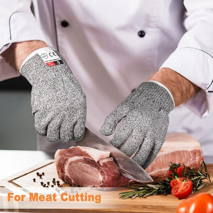 Close-up of a hand wearing a grey Level 5 cut resistant safety glove, securely holding a large onion while the other hand uses a sharp chef's knife for slicing on a cutting board.