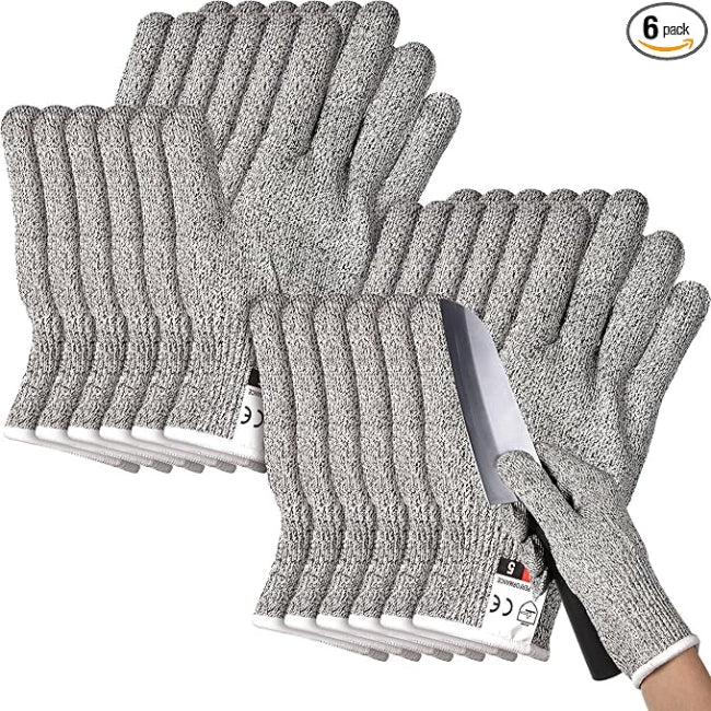 Close-up of a hand wearing a grey Level 5 cut resistant safety glove, securely holding a large onion while the other hand uses a sharp chef's knife for slicing on a cutting board.