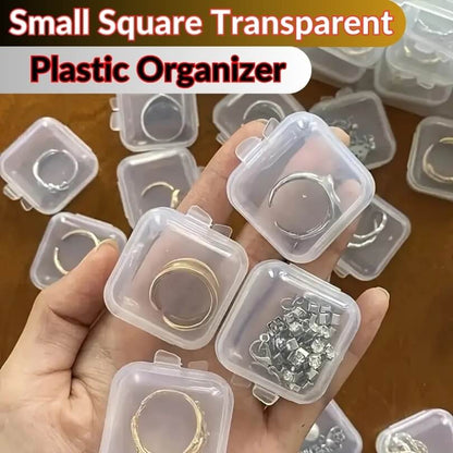 Small square transparent plastic organizer with jewelry on a wooden surface