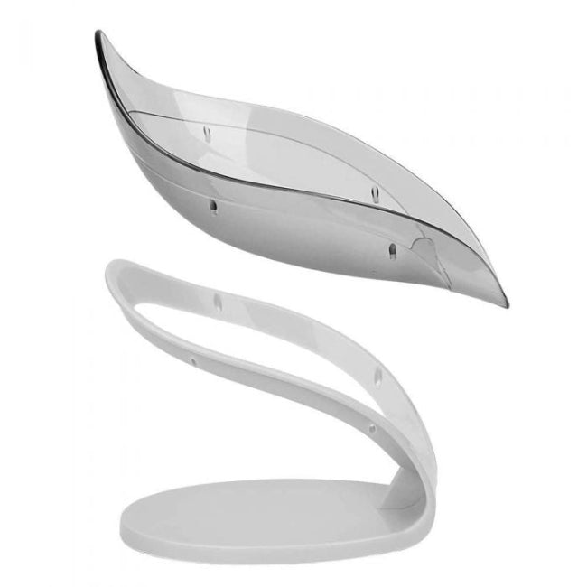 A green leaf-shaped self-draining soap dish holder with a suction cup base, shown on a sink edge, channeling water away from the soap bar.