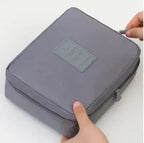 Portable waterproof travel makeup organizer cosmetic bag, open showing internal pockets, unisex toiletry carry case for bathroom storage